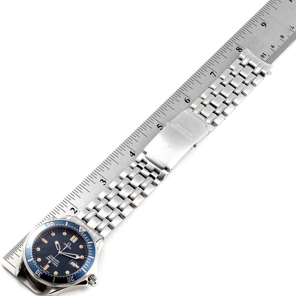 The Omega Seamaster 2541.80.00 Men
s Stainless Steel Blue Dial 2541.80.00 Men
s Stainless Steel Blue Dial watch is shown from a top view, displaying the face, bezel, and metal bracelet on a ruler.