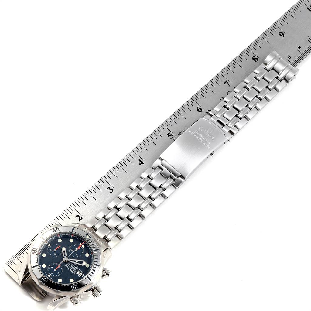 The image shows an Omega Seamaster 2598.80.00 Men
s Stainless Steel Blue Dial 2598.80.00 Men
s Stainless Steel Blue Dial watch laid flat with its bracelet and clasp extended next to a ruler for measurement.