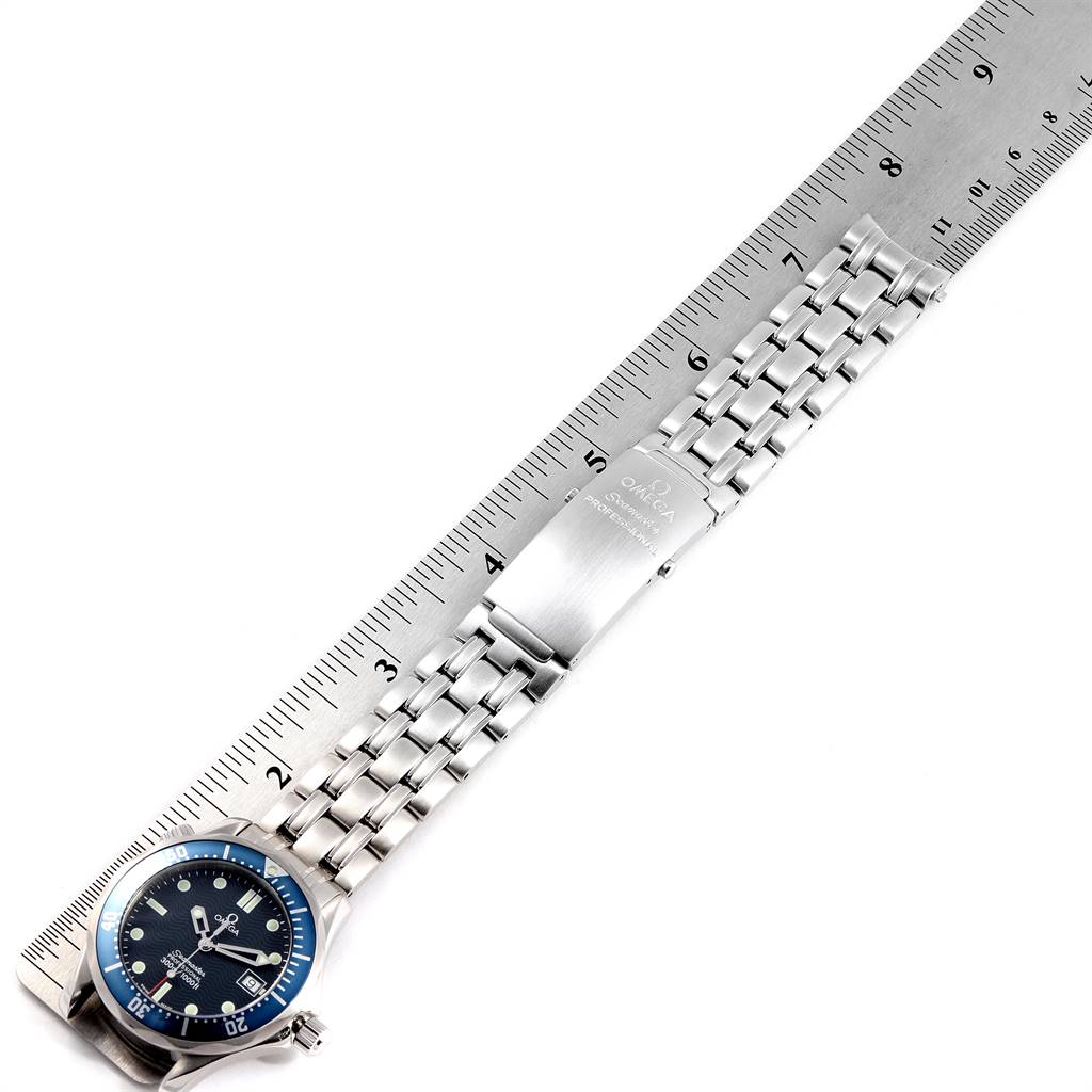 The image shows an Omega Seamaster 2561.80.00 Men
s Stainless Steel Blue Dial 2561.80.00 Men
s Stainless Steel Blue Dial watch lying flat with its stainless steel bracelet, clasp, and part of the dial visible next to a ruler.