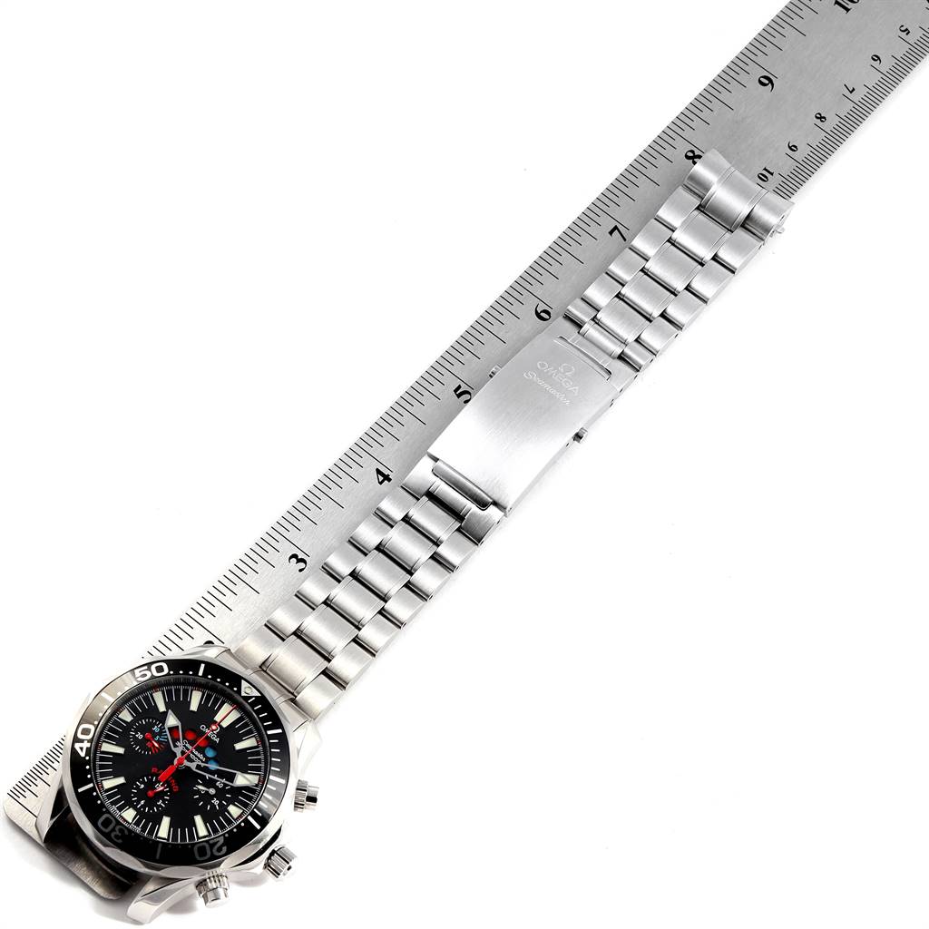 The image shows a stainless steel bracelet Omega Seamaster 2569.50.00 Men
s Stainless Steel Black Dial 2569.50.00 Men
s Stainless Steel Black Dial watch, with the face and clasp situated on a flat surface next to a ruler.