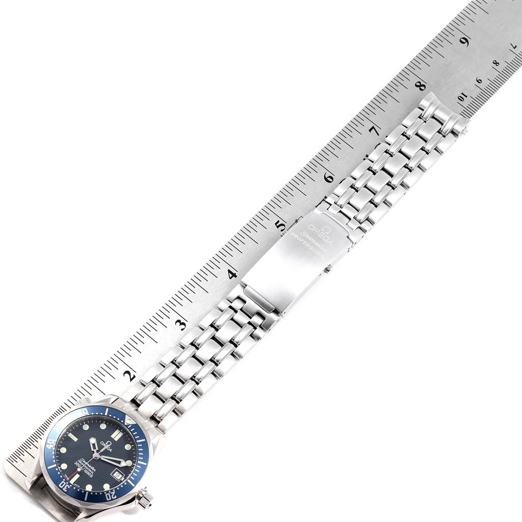 The image shows a top view of an Omega Seamaster 2561.80.00 Men
s Stainless Steel Blue Dial 2561.80.00 Men
s Stainless Steel Blue Dial watch displaying the face, bezel, and bracelet, next to a ruler.