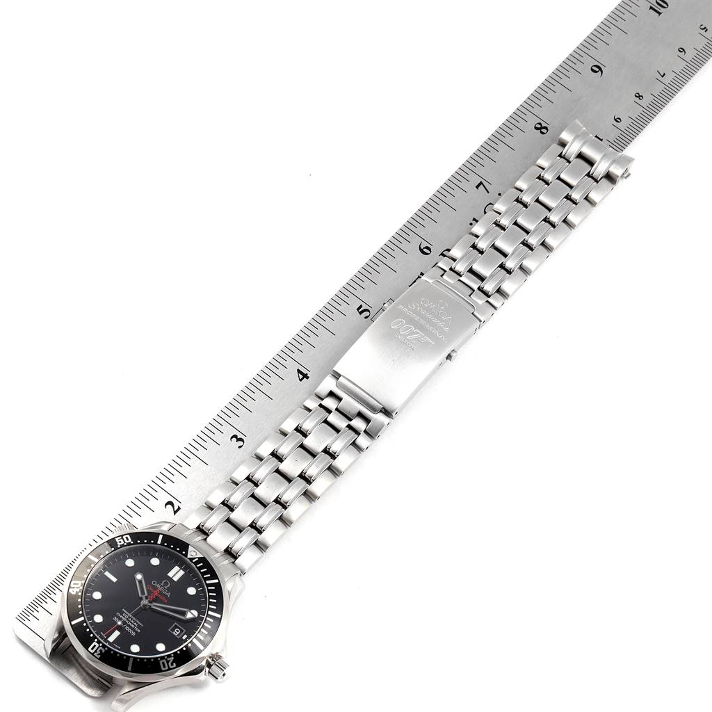 This image shows an Omega Seamaster 212.30.41.20.01.001 Men
s Stainless Steel Black Dial 212.30.41.20.01.001 Men
s Stainless Steel Black Dial watch lying flat next to a ruler, displaying the face and metal strap with a 007 engraving.