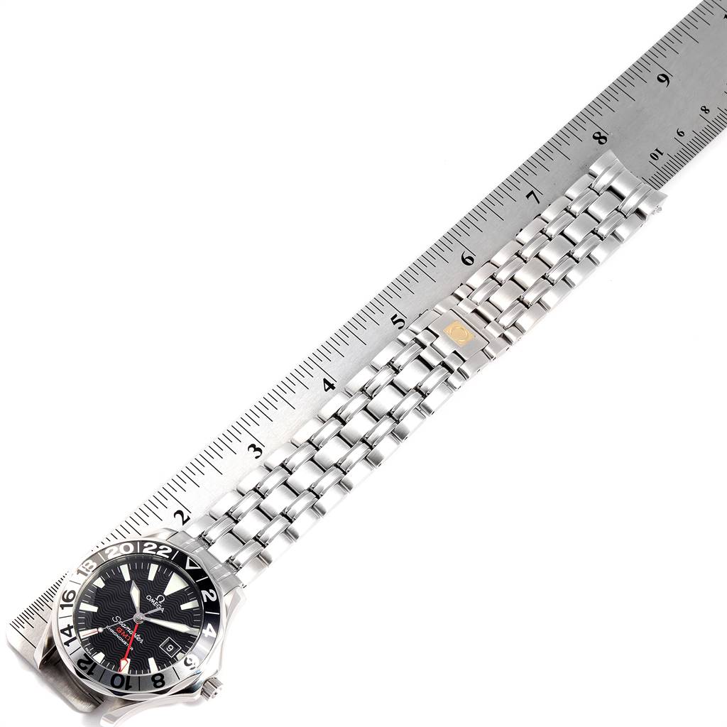 The image shows an Omega Seamaster 2534.50.00 Men
s Stainless Steel Black Dial 2534.50.00 Men
s Stainless Steel Black Dial watch laid flat with its bracelet next to a ruler, highlighting the length and design of the bracelet.