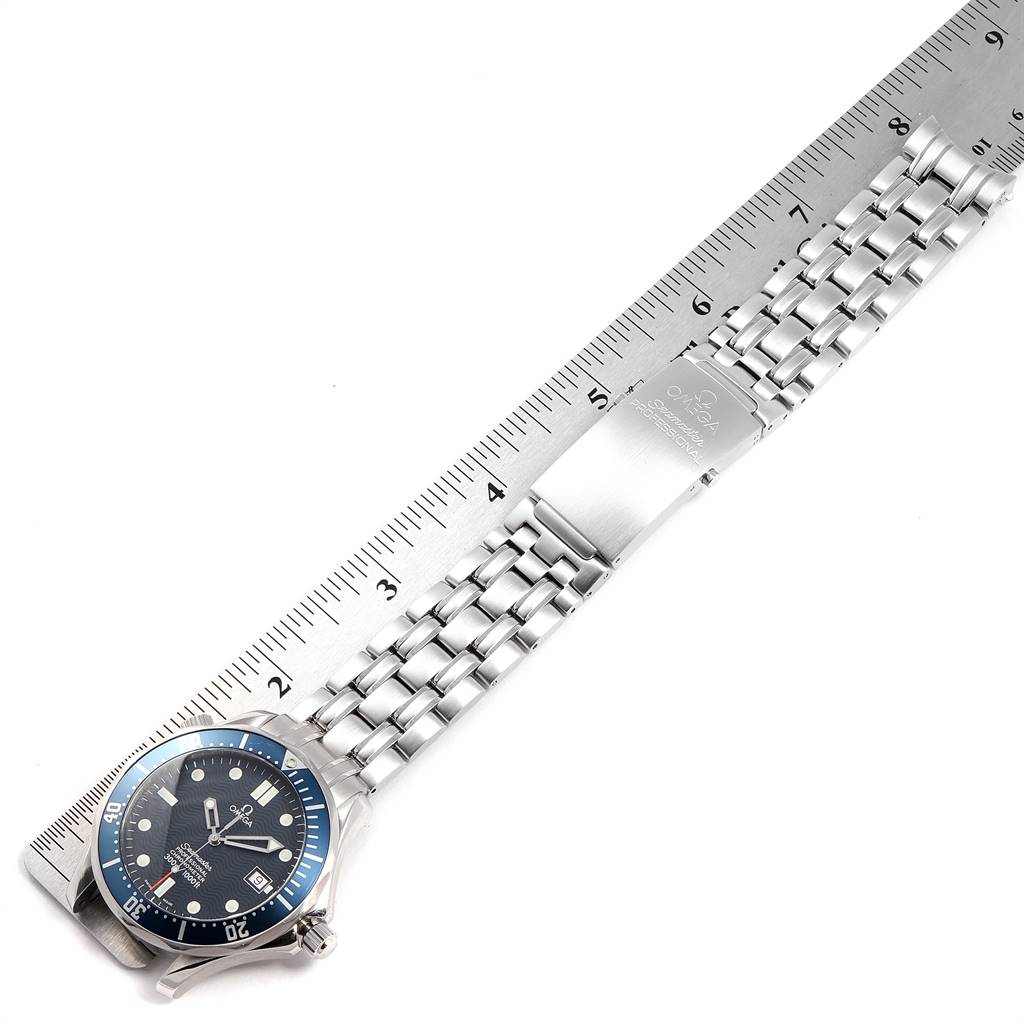 The Omega Seamaster 2531.80.00 Men
s Stainless Steel Blue Dial 2531.80.00 Men
s Stainless Steel Blue Dial watch is shown from above, displaying its dial, bezel, bracelet, and clasp next to a ruler for scale.