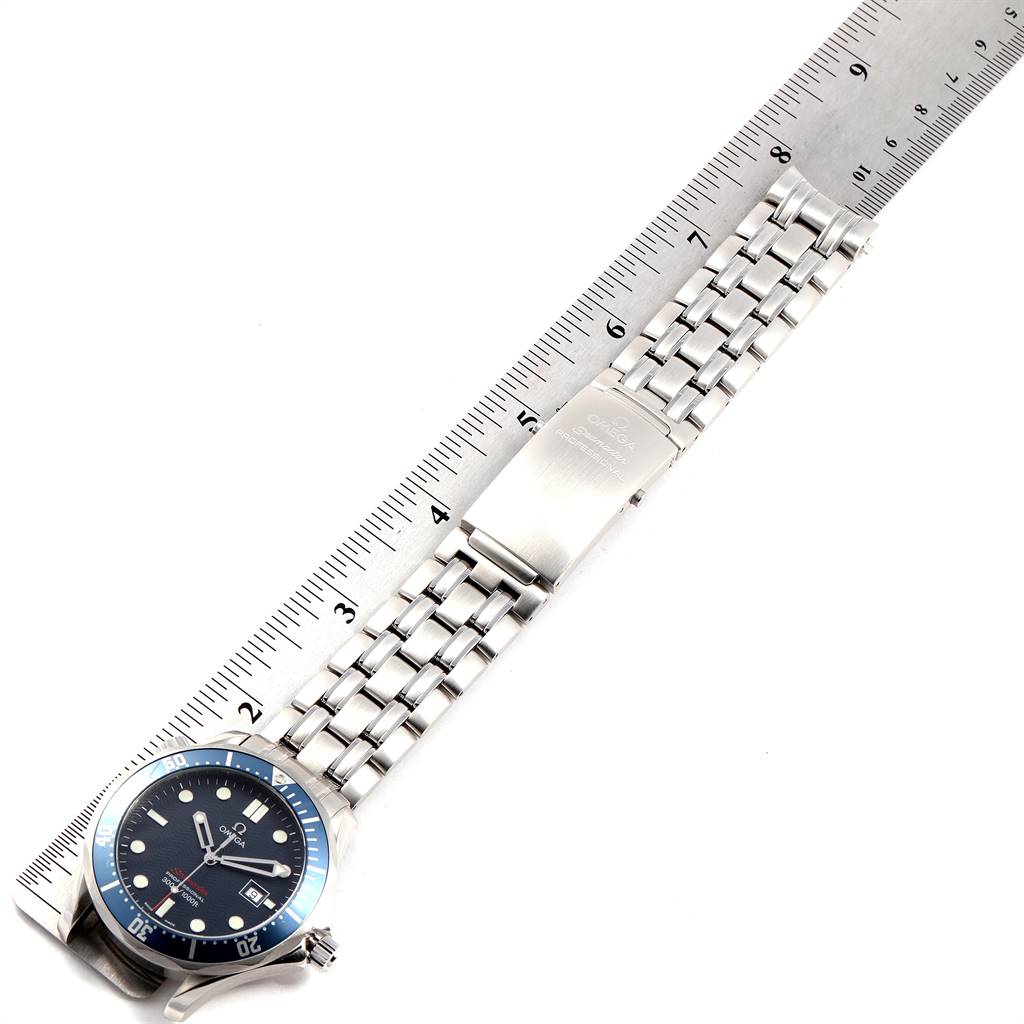 The image shows an Omega Seamaster 2221.80.00 Men
s Stainless Steel Blue Dial 2221.80.00 Men
s Stainless Steel Blue Dial watch laid flat against a ruler, displaying the face, bracelet, and clasp.