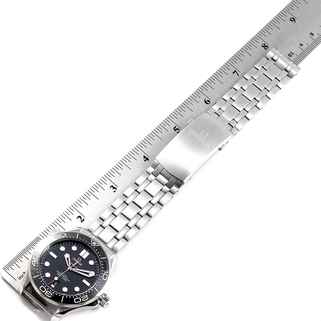 The image shows an Omega Seamaster 210.30.42.20.01.001 Men
s Stainless Steel Black Dial 210.30.42.20.01.001 Men
s Stainless Steel Black Dial watch lying flat next to a ruler, displaying its face, bezel, and bracelet with clasp.