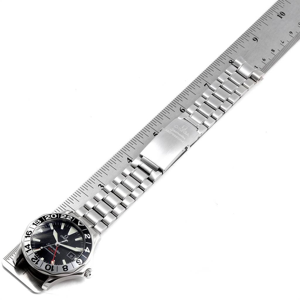 The Omega Seamaster 2536.50.00 Men
s Stainless Steel Black Dial 2536.50.00 Men
s Stainless Steel Black Dial watch is shown laid flat with its full bracelet alongside a ruler for scale.