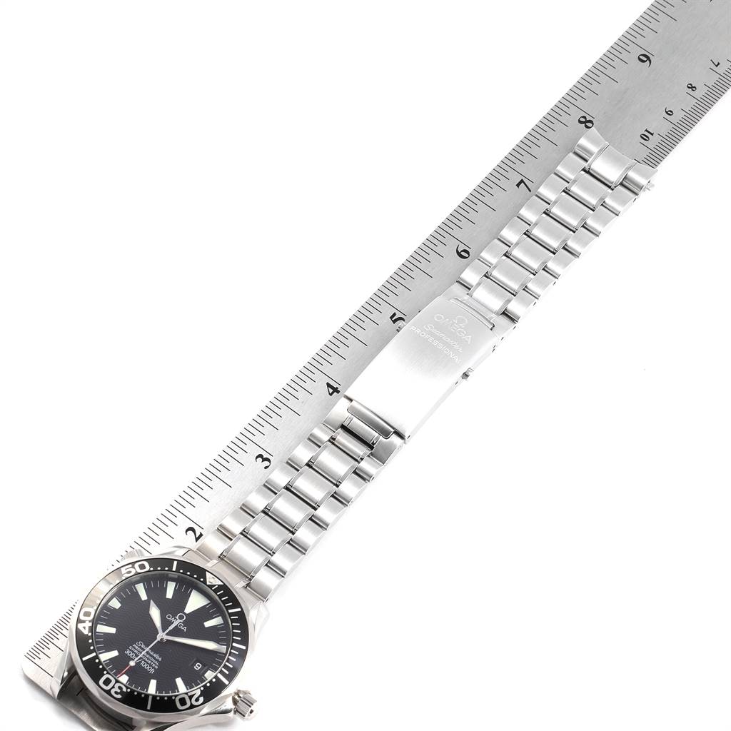 The Omega Seamaster 2254.50.00 Men
s Stainless Steel Black Dial 2254.50.00 Men
s Stainless Steel Black Dial watch is shown from a top-down angle, displaying the face and the full metal bracelet laid next to a ruler.