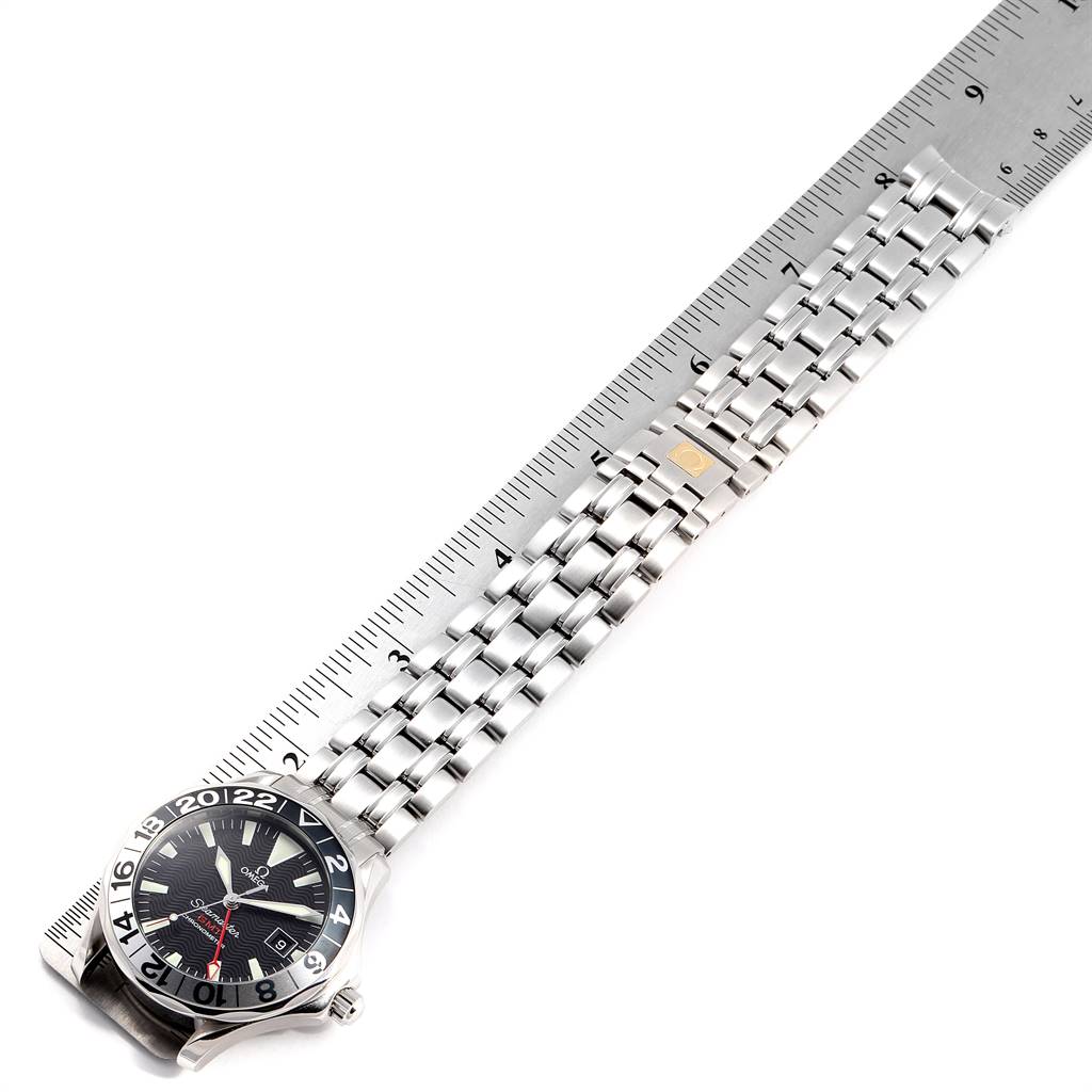 This image shows the Omega Seamaster 2234.50.00 Men
s Stainless Steel Black Dial 2234.50.00 Men
s Stainless Steel Black Dial watch laying flat with its band aligned next to a ruler for scale.