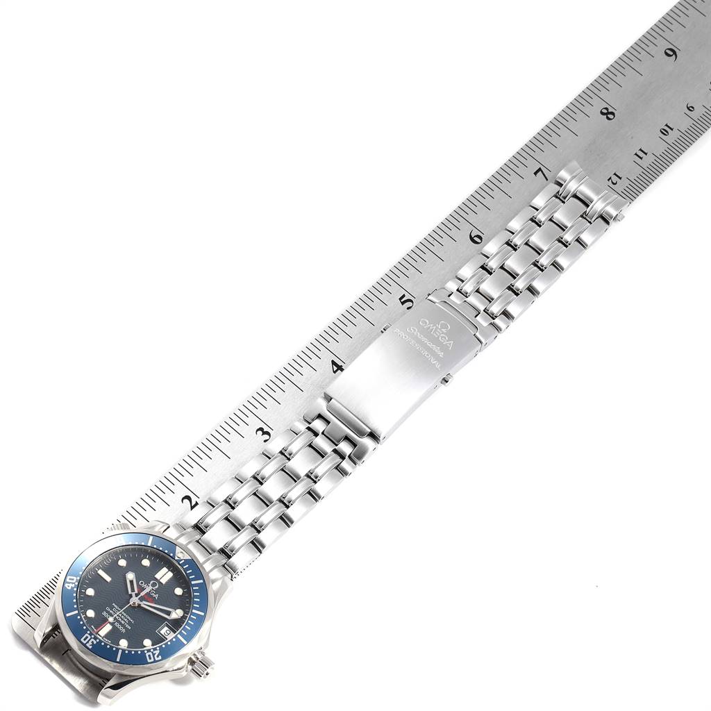 The image shows an Omega Seamaster 2221.80.00 Men
s Stainless Steel Blue Dial 2221.80.00 Men
s Stainless Steel Blue Dial watch and its metal bracelet laid flat against a ruler.