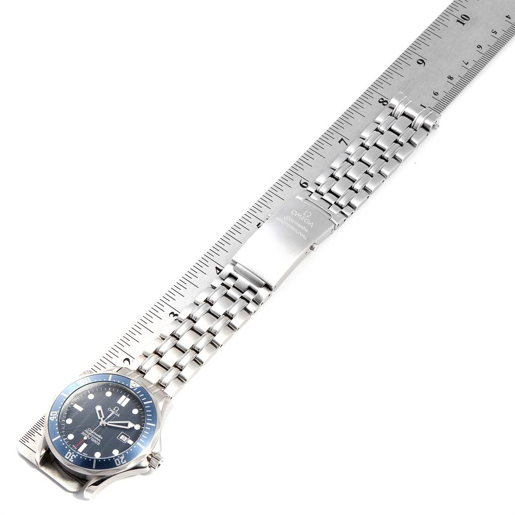 The Omega Seamaster 2541.80.00 Men
s Stainless Steel Blue Dial 2541.80.00 Men
s Stainless Steel Blue Dial watch is shown from a top-down angle with its metal bracelet laid out and aligned with a ruler.