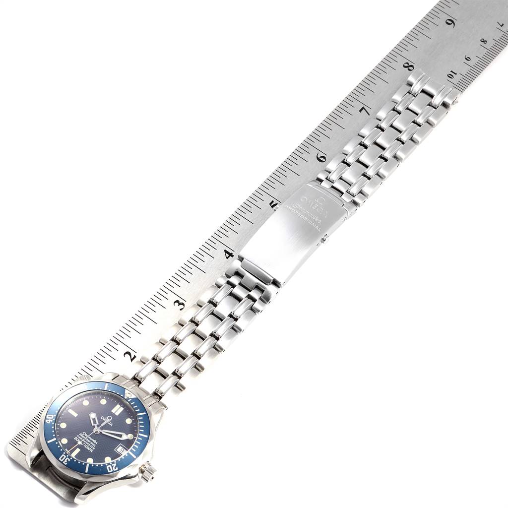 This image shows an Omega Seamaster 2551.80.00 Men
s Blue Dial 2551.80.00 Men
s Blue Dial watch and its metal bracelet placed alongside a ruler for measurement.