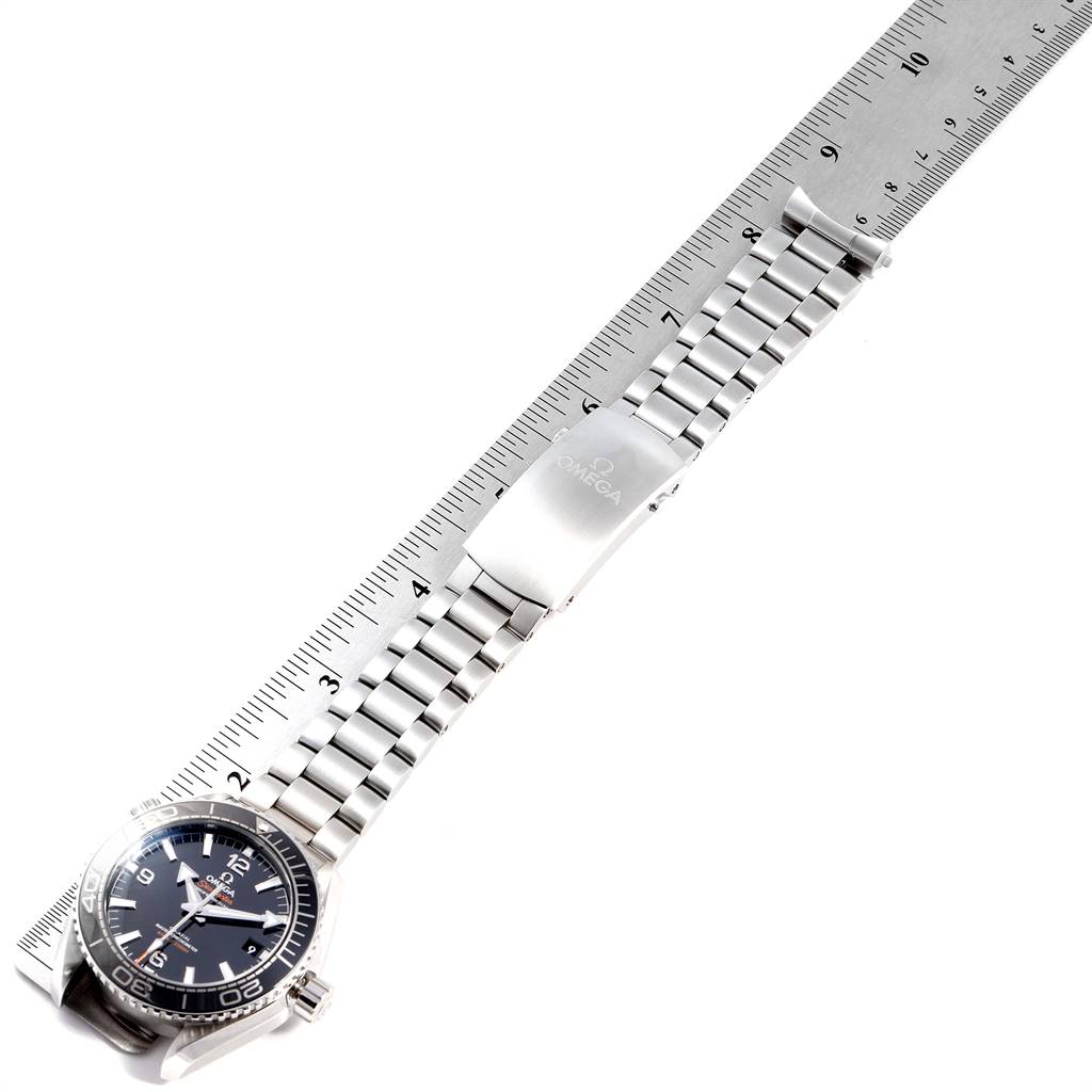 The image shows the Omega Planet Ocean 215.30.44.21.01.001 Men
s Stainless Steel Black Dial 215.30.44.21.01.001 Men
s Stainless Steel Black Dial watch lying flat, displaying the face, bracelet, and clasp, next to a ruler for scale.