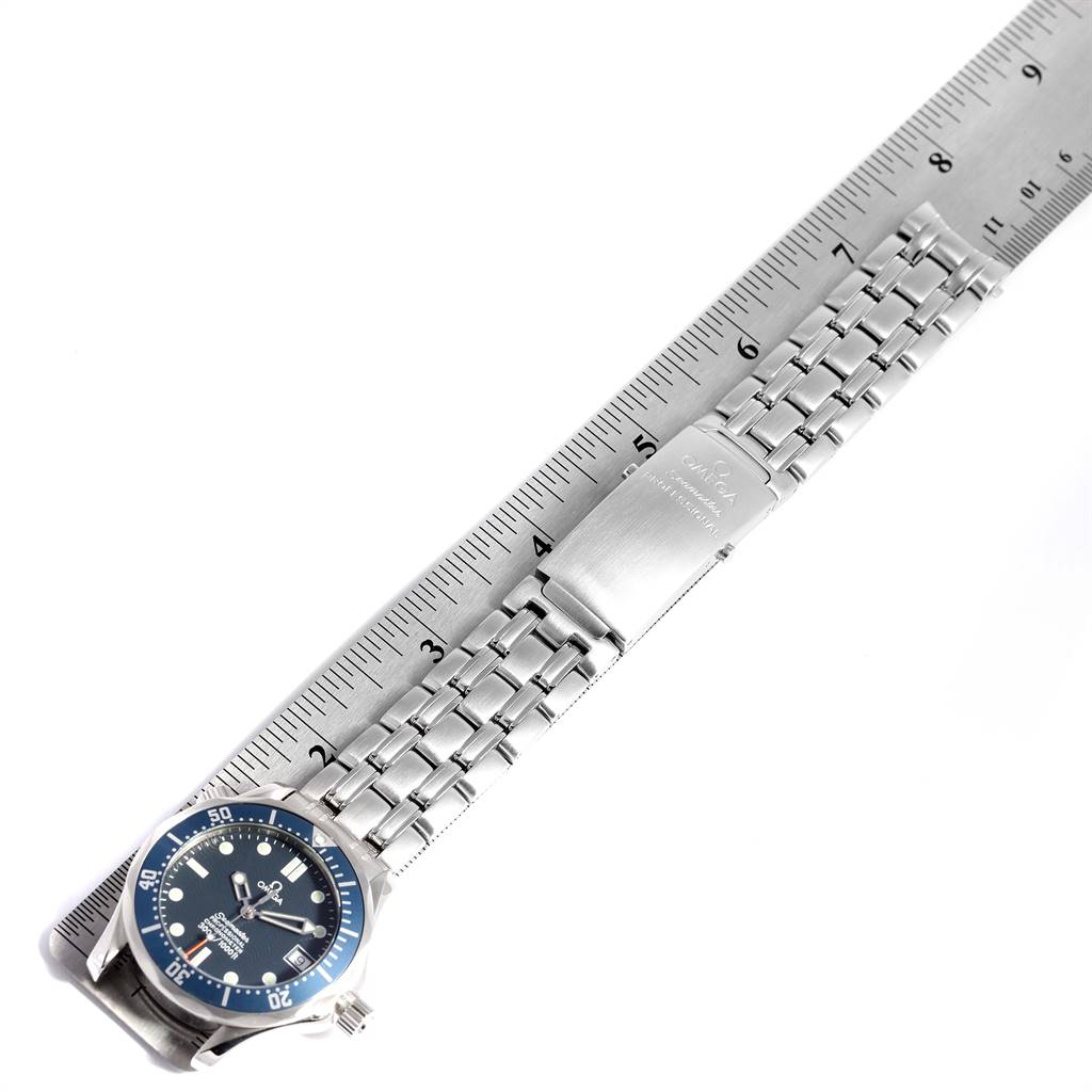 The Omega Seamaster 2551.80.00 Men
s Stainless Steel Blue Dial 2551.80.00 Men
s Stainless Steel Blue Dial watch is shown flat against a ruler, displaying its blue dial, metal bracelet, and clasp.