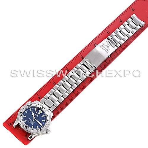 The image shows an Omega Seamaster 22538000 Stainless Steel Blue Dial 22538000 Stainless Steel Blue Dial watch laid flat, emphasizing its metal bracelet and clasp along with the dial and bezel, placed next to a red ruler.