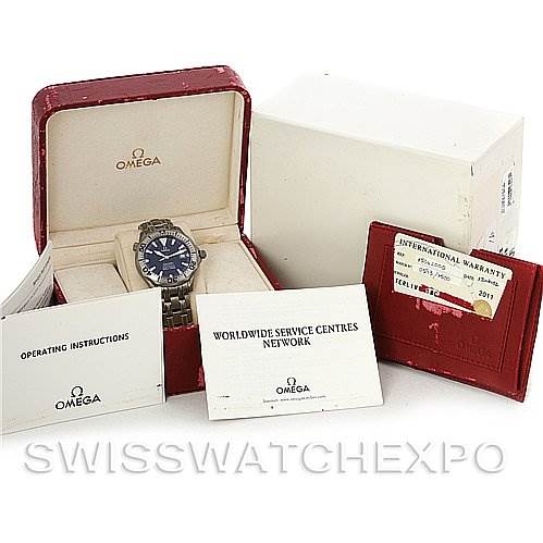 The image shows an Omega Seamaster 2232.80.00 Men's Titanium Blue Dial 2232.80.00 Men's Titanium Blue Dial watch with its box, operating instructions, worldwide service centers booklet, and an international warranty card.