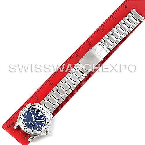 The Omega Seamaster 2263.80.00 Men's Stainless Steel Blue Dial 2263.80.00 Men's Stainless Steel Blue Dial watch is shown from an overhead angle, including both the dial and the entire metal bracelet against a red measuring scale.