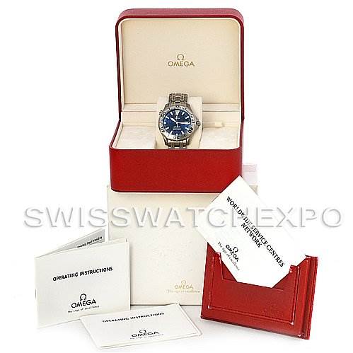 The image shows an Omega Seamaster 2231.80.00 Men
s Stainless Steel Blue Dial 2231.80.00 Men
s Stainless Steel Blue Dial watch at an angle, inside its box, with accompanying booklets and a cardholder displayed around it.