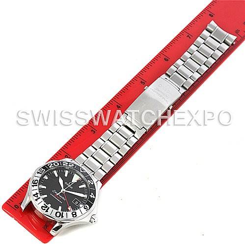 This image shows an Omega Seamaster 2534.50 Men
s Stainless Steel Black Dial 2534.50 Men
s Stainless Steel Black Dial watch placed alongside a red ruler, showcasing its front dial and metal bracelet.