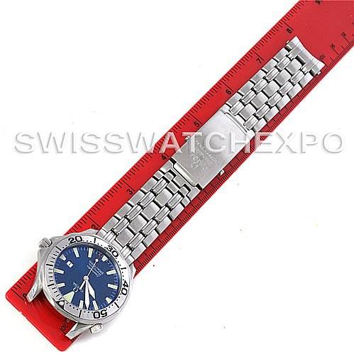 The image shows an Omega Seamaster 2065.80 Men
s Stainless Steel Blue Dial 2065.80 Men
s Stainless Steel Blue Dial watch laying flat against a red measuring ruler, highlighting its bracelet and clasp.