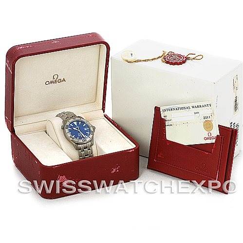 The image shows an Omega Seamaster 2232.80.00 Men
s Titanium Blue Dial 2232.80.00 Men
s Titanium Blue Dial watch inside its red case, along with its warranty card and packaging.