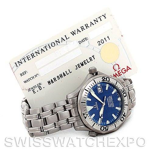The image shows an Omega Seamaster 2231.80.00 Men's Titanium Blue Dial 2231.80.00 Men's Titanium Blue Dial watch with a stainless steel bracelet alongside its international warranty card.