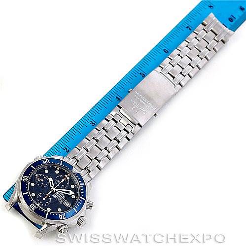 The Omega Seamaster 2599.80.00 Men
s Stainless Steel Blue Dial 2599.80.00 Men
s Stainless Steel Blue Dial watch is laid flat, displaying the face, bezel, crown, bracelet, and clasp next to a blue ruler for scale.