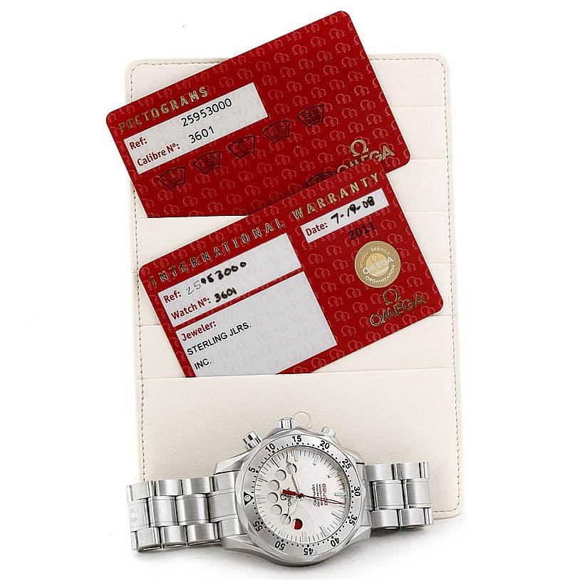 The image shows an Omega Seamaster 2595.30.00 Men
s Stainless Steel Silver Dial 2595.30.00 Men
s Stainless Steel Silver Dial watch and its warranty cards, photographed from above.