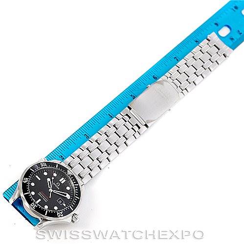 The image shows an overhead view of an Omega Seamaster 212.30.41.61.01.001 Men
s Stainless Steel Black Dial 212.30.41.61.01.001 Men
s Stainless Steel Black Dial watch, including its face, metal bracelet, and clasp, alongside a blue ruler for scale.