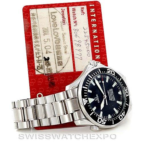 The image shows an Omega Seamaster 2254.50.00 Men
s Stainless Steel Black Dial 2254.50.00 Men
s Stainless Steel Black Dial watch with its bracelet and bezel, placed in front of a red warranty card.