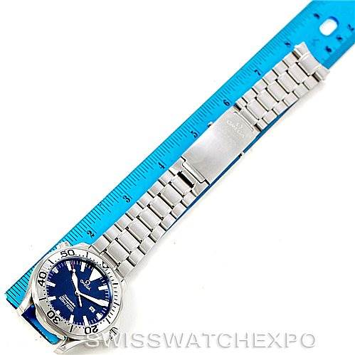 The Omega Seamaster 2265.80.00 Men
s Stainless Steel Blue Dial 2265.80.00 Men
s Stainless Steel Blue Dial watch is shown at an angle displaying the entire band, clasp, and dial next to a blue ruler.