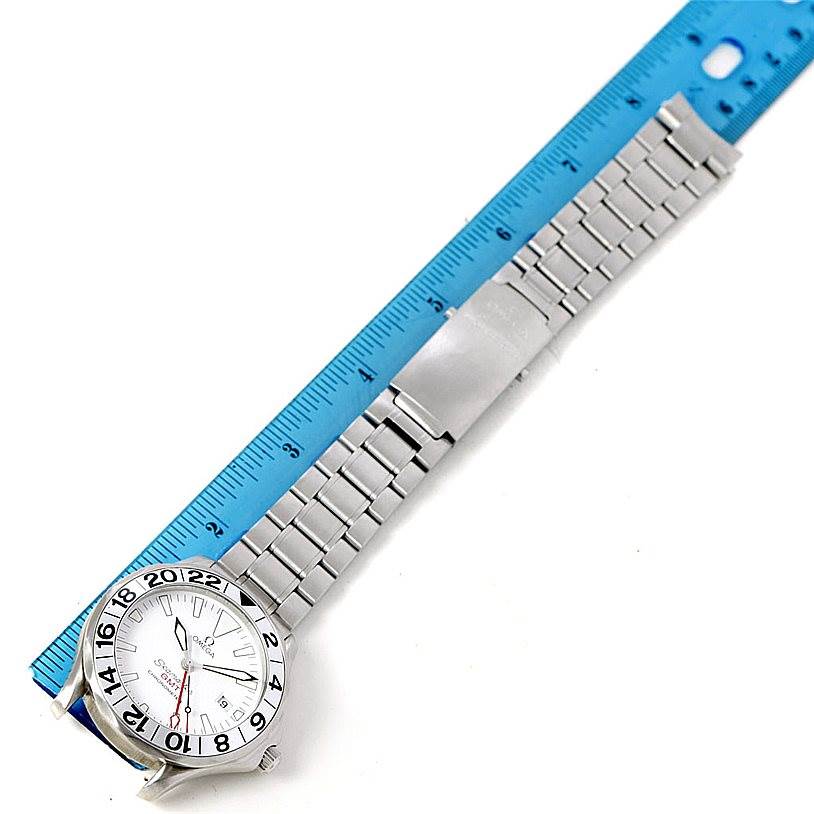 The Omega Seamaster 2538.20.00 Men
s Stainless Steel White Dial 2538.20.00 Men
s Stainless Steel White Dial watch is shown from above, displaying its face, bezel, and metal bracelet next to a ruler for scale.