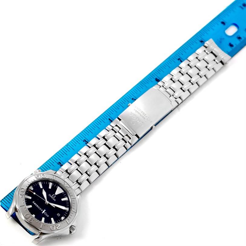 The image shows an Omega Seamaster 2533.50.00 Men
s Stainless Steel Black Dial 2533.50.00 Men
s Stainless Steel Black Dial watch laid flat with a silver bracelet and clasp, alongside a blue measuring ruler.