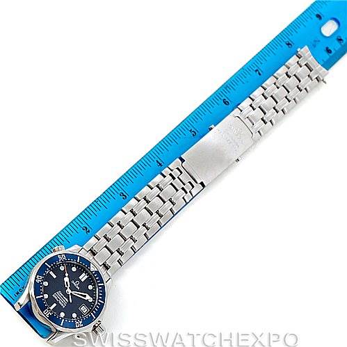 The image shows an Omega Seamaster 2551.80.00 Men
s Stainless Steel Blue Dial 2551.80.00 Men
s Stainless Steel Blue Dial watch laid out flat next to a blue ruler, highlighting the watch face, bracelet, and clasp.