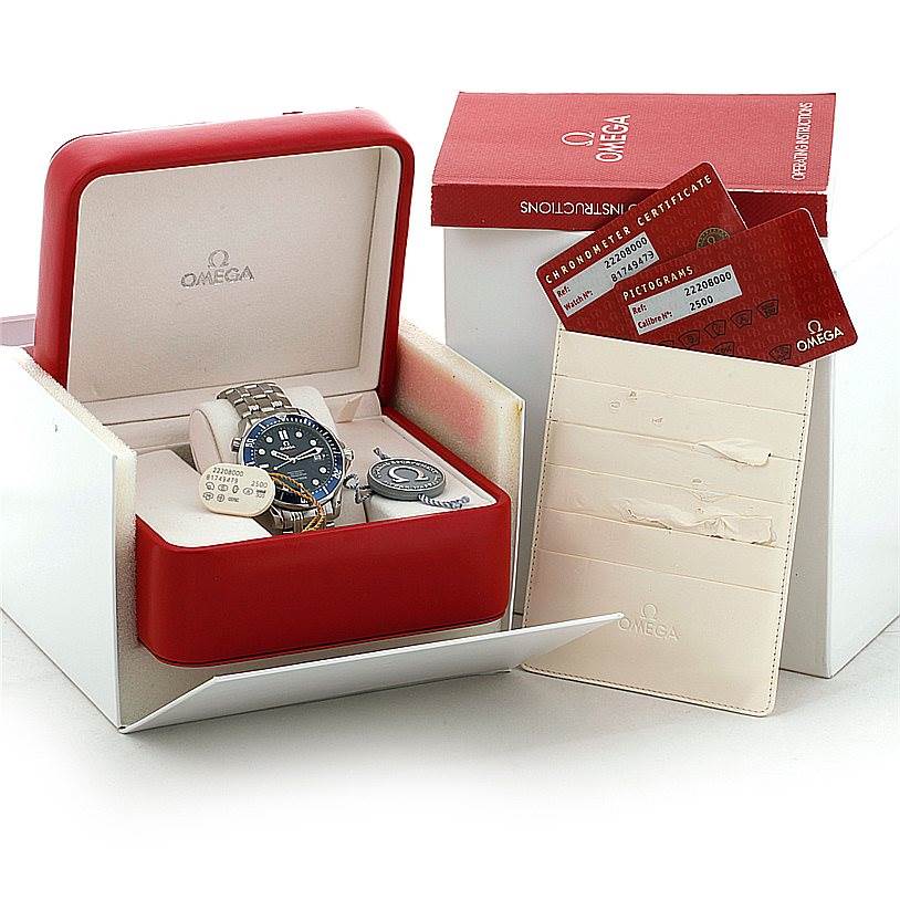 The image shows the Omega Seamaster 2220.80.00 Men
s Stainless Steel Blue Dial 2220.80.00 Men
s Stainless Steel Blue Dial watch in an angled view, inside its box with the instruction booklet, certificate, and tags.
