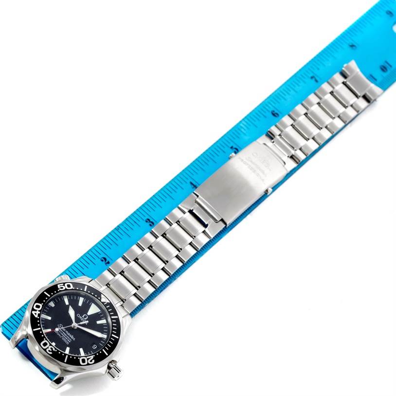 The image shows the Omega Seamaster 2252.50.00 Men
s Stainless Steel Black Dial 2252.50.00 Men
s Stainless Steel Black Dial watch laid flat with its metal bracelet and clasp, next to a blue ruler for scale.