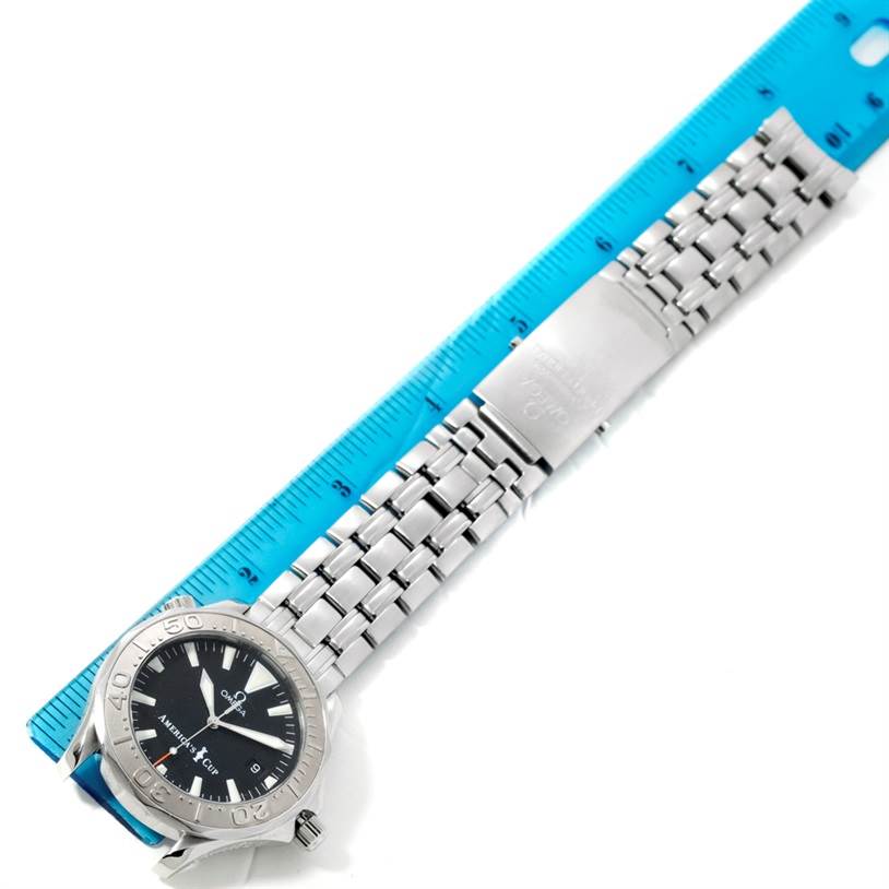 The image shows the Omega Seamaster 2533.50.00 Men
s Stainless Steel Black Dial 2533.50.00 Men
s Stainless Steel Black Dial watch laid flat with its entire bracelet and clasp visible, alongside a blue ruler.