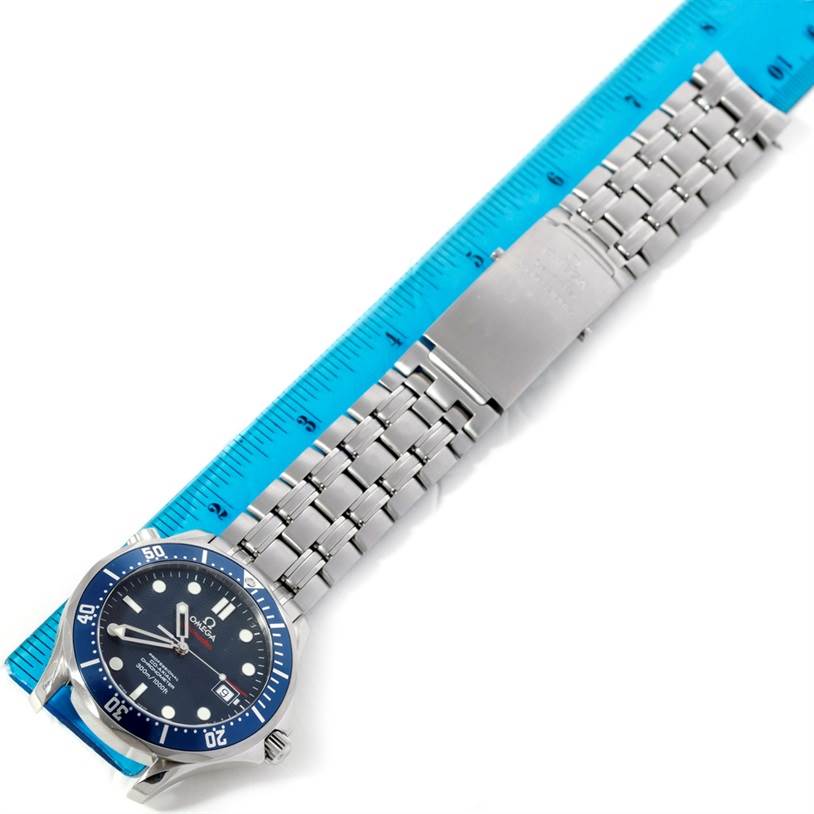 The image shows an Omega Seamaster 2220.80.00 Men
s Stainless Steel Blue Dial 2220.80.00 Men
s Stainless Steel Blue Dial watch laid flat with a metal bracelet and clasp, aligned next to a blue ruler for scale.