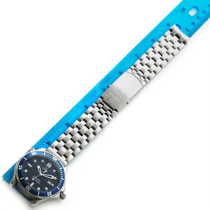 The image shows a full view of the Omega Seamaster 2541.80.00 Men
s Stainless Steel Blue Dial 2541.80.00 Men
s Stainless Steel Blue Dial watch, including its face, bezel, and metal bracelet, aligned next to a blue ruler.