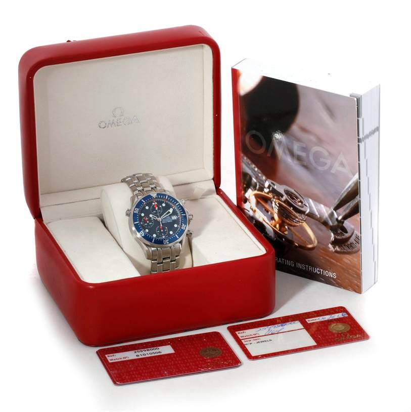 The image shows an Omega Seamaster 2599.80.00 Men
s Stainless Steel Blue Dial 2599.80.00 Men
s Stainless Steel Blue Dial watch in its red box, accompanied by an instruction manual and two warranty cards.