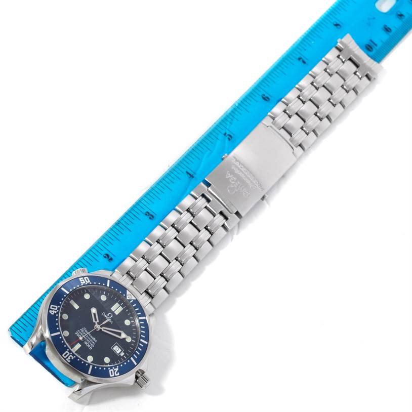 The image shows a top-down view of a Seamaster model by Omega, focusing on the watch face, bracelet, and clasp, next to a ruler.