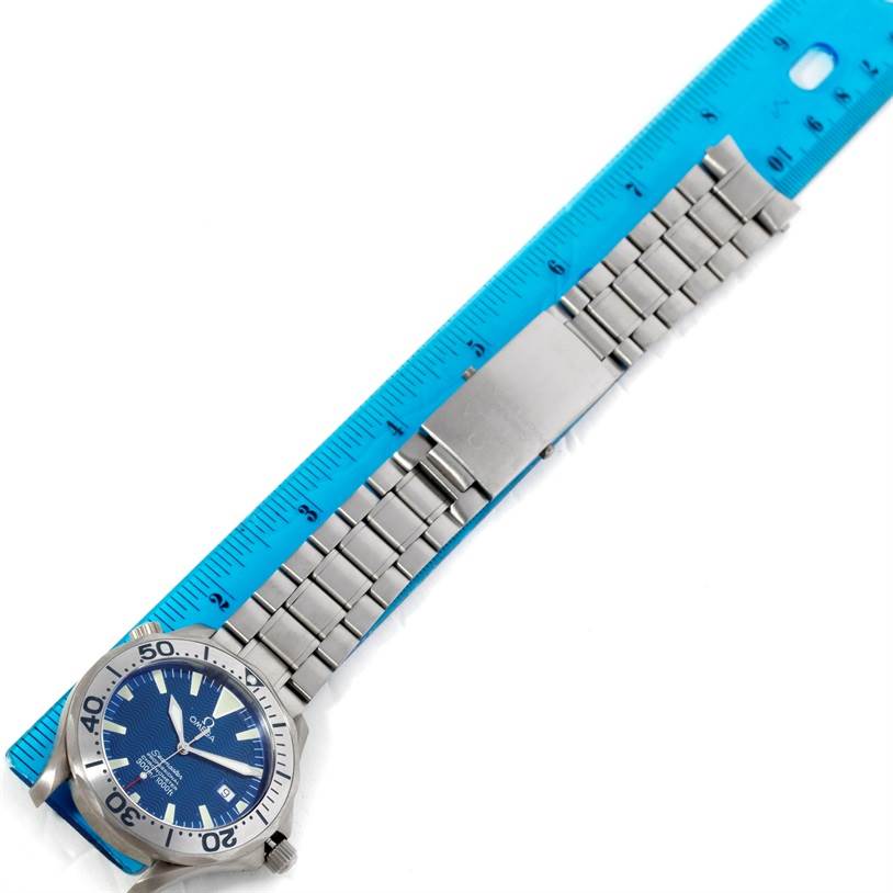 A side view of the Omega Seamaster 2231.80.00 Men
s Titanium Blue Dial 2231.80.00 Men
s Titanium Blue Dial watch shows the face, bezel, bracelet, and clasp, next to a ruler for measurement.