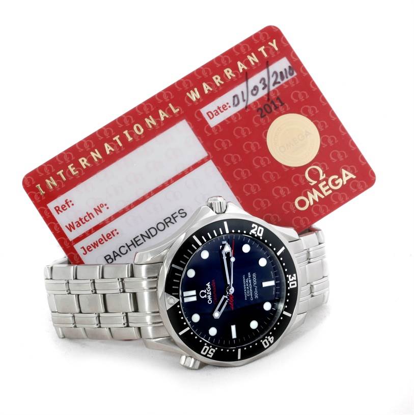 The image shows an Omega Seamaster 212.30.41.20.01.001 Men
s Stainless Steel Black Dial 212.30.41.20.01.001 Men
s Stainless Steel Black Dial watch with a bracelet, positioned next to its international warranty card.