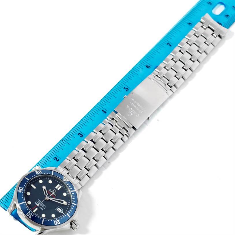 The image shows an Omega Seamaster 2220.80.00 Men's Stainless Steel Blue Dial 2220.80.00 Men's Stainless Steel Blue Dial watch laid flat with a blue ruler placed alongside it, highlighting the face, bezel, and bracelet.