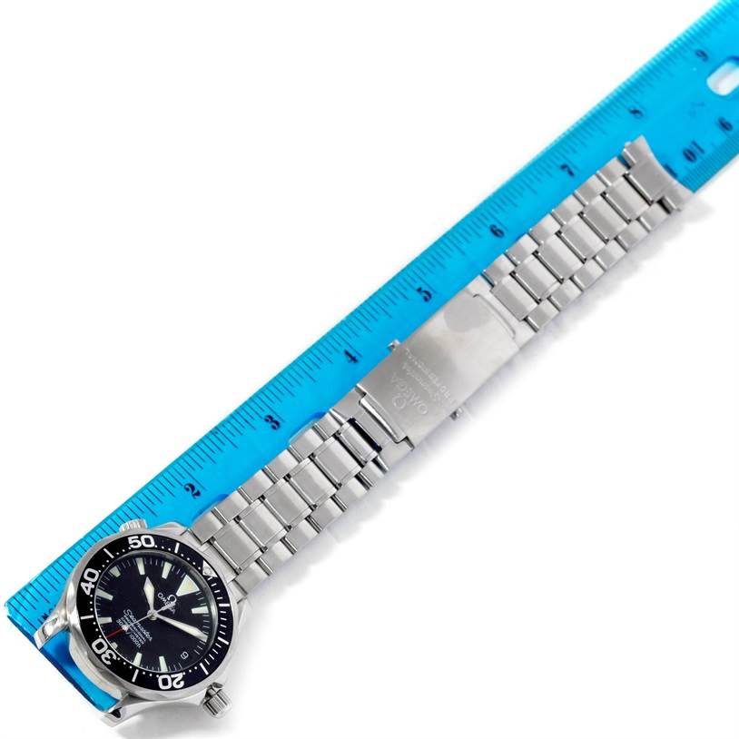 The Omega Seamaster 2252.50.00 Men
s Stainless Steel Black Dial 2252.50.00 Men
s Stainless Steel Black Dial watch is shown laid flat, with its stainless steel bracelet and clasp fully visible alongside a blue ruler.