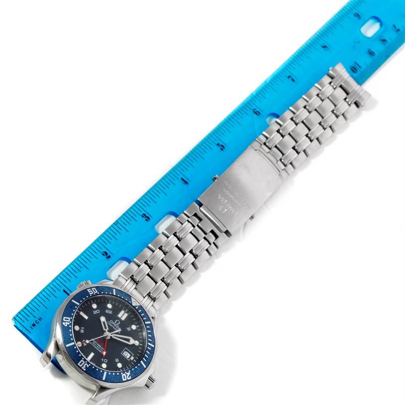 The image shows an Omega Seamaster 2535.80.00 Men
s Stainless Steel Blue Dial 2535.80.00 Men
s Stainless Steel Blue Dial watch placed next to a blue ruler, featuring its face, bezel, and metal bracelet.