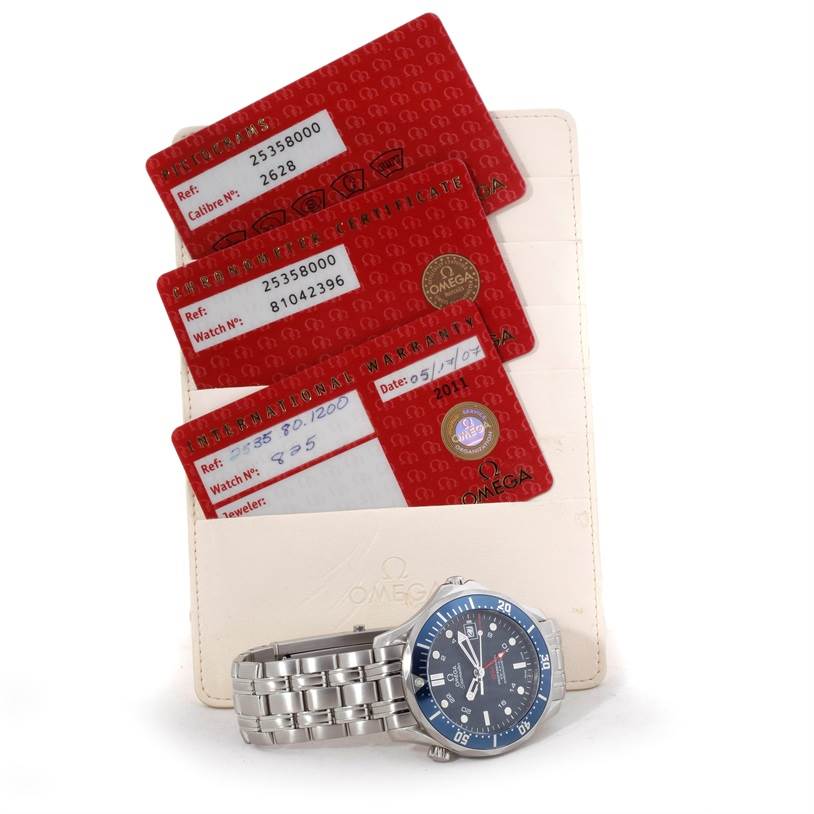 The image shows an Omega Seamaster 2535.80.00 Men's Stainless Steel Blue Dial 2535.80.00 Men's Stainless Steel Blue Dial watch lying flat with its dial visible, alongside the certification cards and a cardholder.