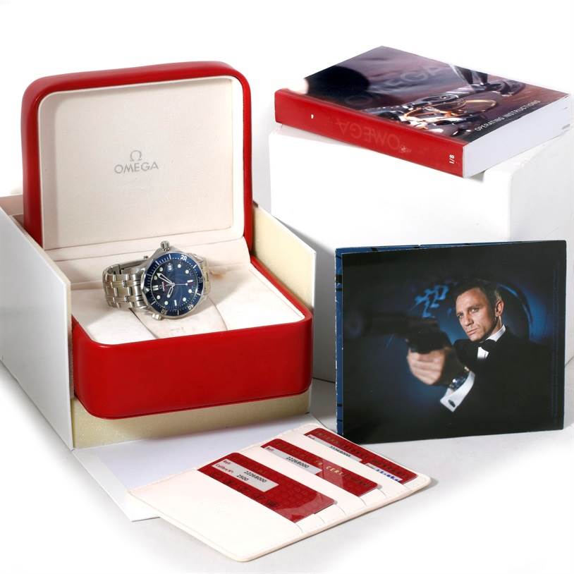 The Omega Seamaster 2226.80.00 Men
s Stainless Steel Blue Dial 2226.80.00 Men
s Stainless Steel Blue Dial watch is shown at an angle in its open box, along with accessories including cards and a photo.