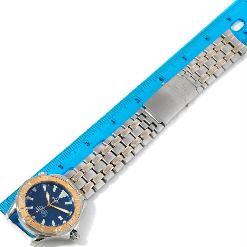 The image shows an Omega Seamaster 2455.80.00 Men
s Stainless Steel Blue Dial 2455.80.00 Men
s Stainless Steel Blue Dial watch laid flat adjacent to a blue ruler, highlighting its strap and case.