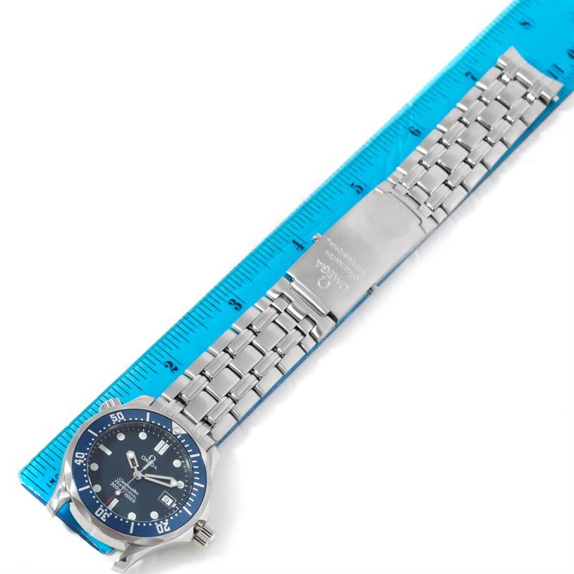 The Omega Seamaster 2561.80.00 Men's Stainless Steel Blue Dial 2561.80.00 Men's Stainless Steel Blue Dial watch is shown from above, displaying the face, bezel, and full metal bracelet next to a blue ruler.